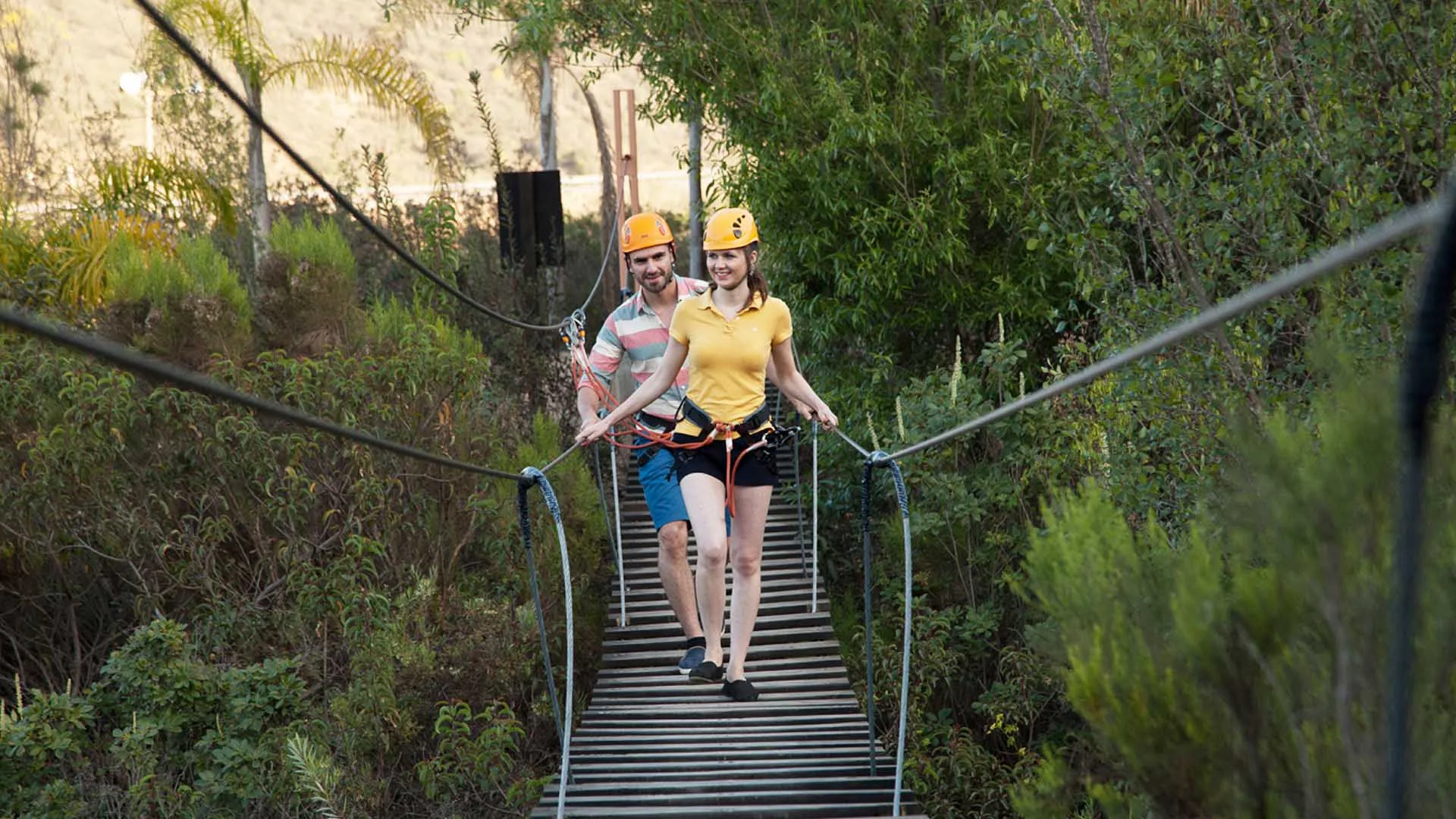 Two visitors crossing a suspended bridge on the Las Cañadas canopy circuit