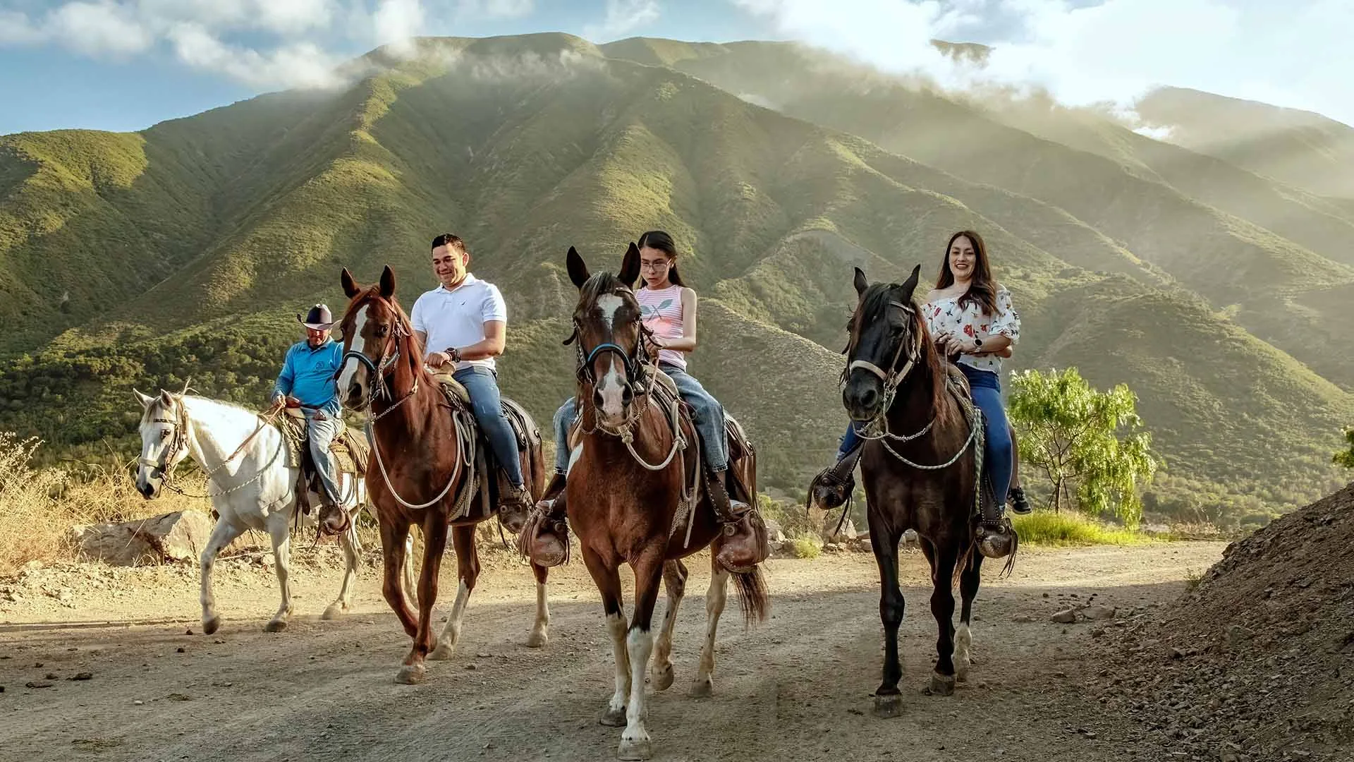 A group riding horses along a mountain trail at Las Cañadas