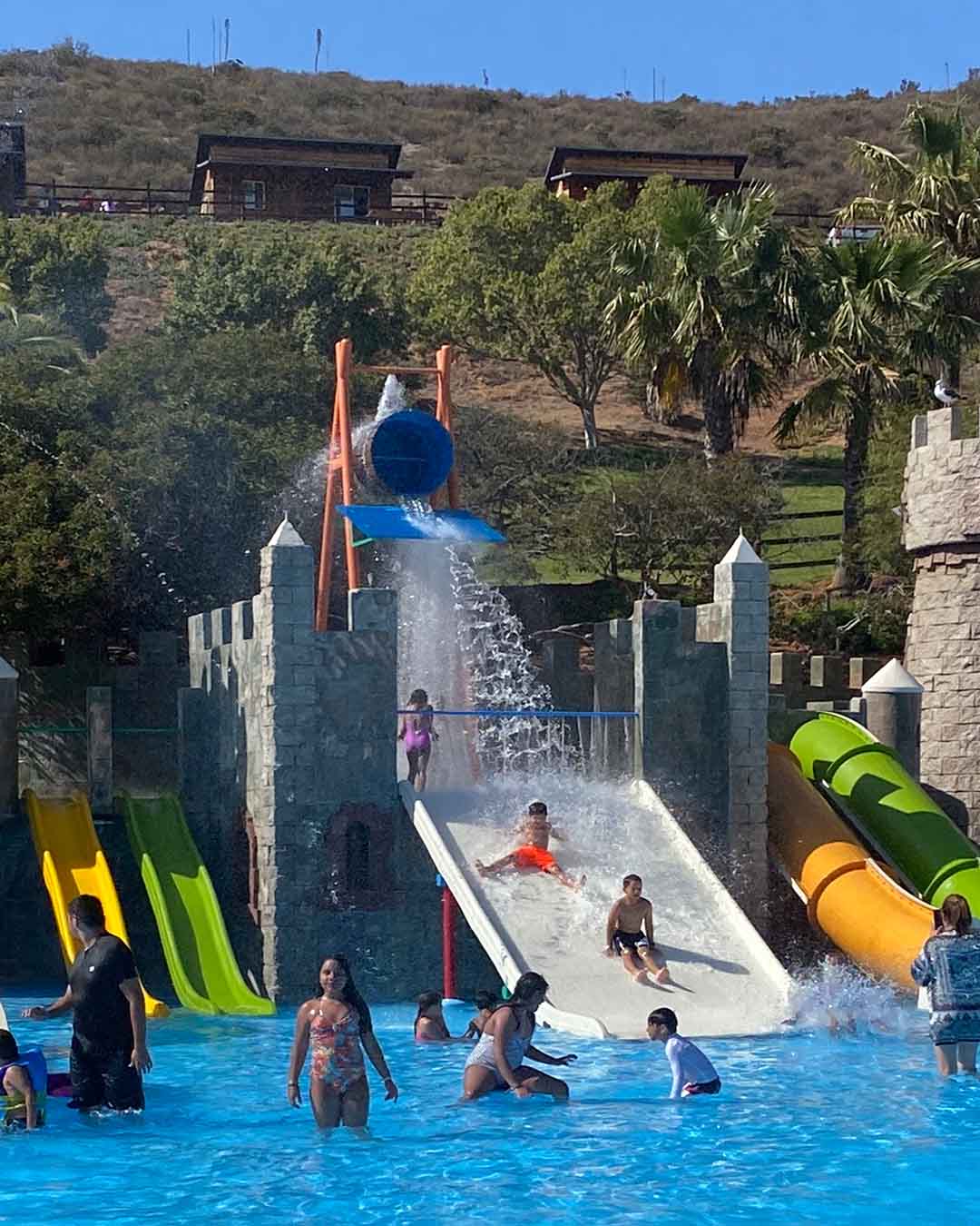 Children playing on the colorful pirate-themed water fortress at Las Cañadas